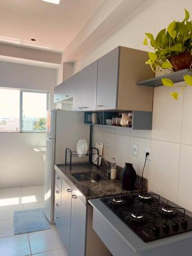 a kitchen with white cabinets and a stove top oven at Apê tapajós in Santarém