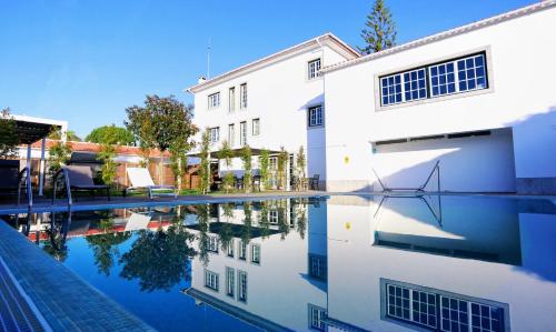 a reflection of a building in a pool of water at Art 4 You Carcavelos Suites in Carcavelos