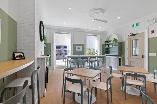 a restaurant with tables and chairs in a room at HI Halifax Heritage House Hostel in Halifax
