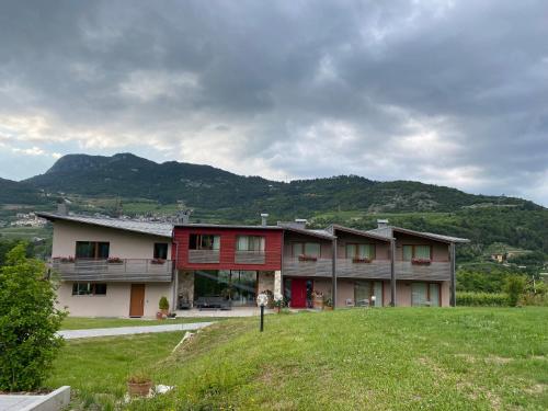a large building in a field with mountains in the background at Agritur Verderame in Trento