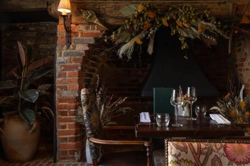 a dining room with a table and a brick wall at The Crown Inn in Bishops Waltham