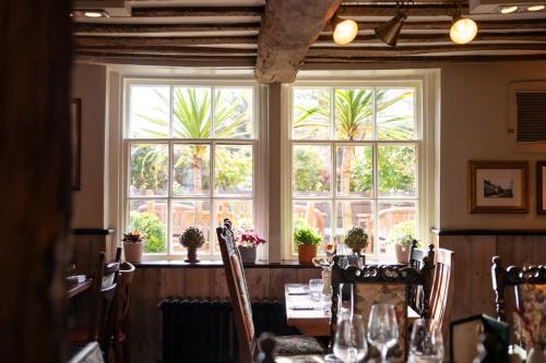 a dining room with a table and a large window at The Crown Inn in Bishops Waltham