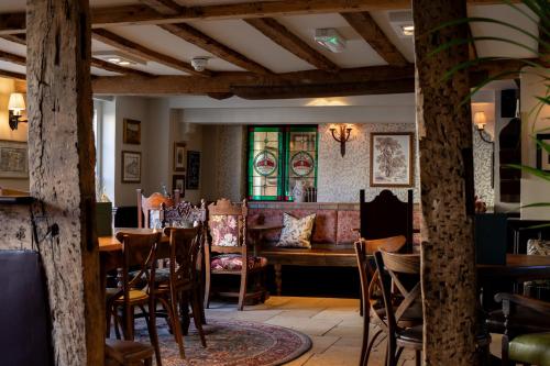 a restaurant with a table and chairs and a couch at The Crown Inn in Bishops Waltham