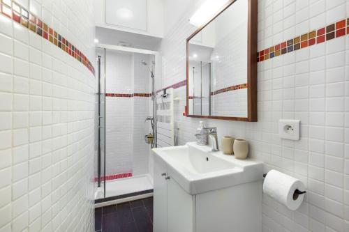une salle de bain blanche avec un lavabo et une douche dans l'établissement Studio Saint Sulpice, à Paris