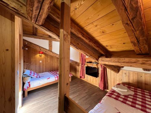 una stanza con due letti in una cabina di legno di CHALET de charme 13 personnes avec Sauna SKI O PIEDS a Saint-Martin-de-Belleville
