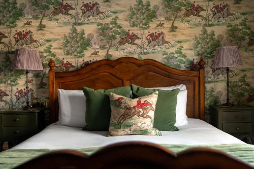 a bedroom with a bed with a painting on the wall at The Crown Inn in Bishops Waltham