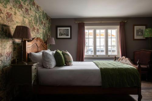 a bedroom with a large bed and a window at The Crown Inn in Bishops Waltham