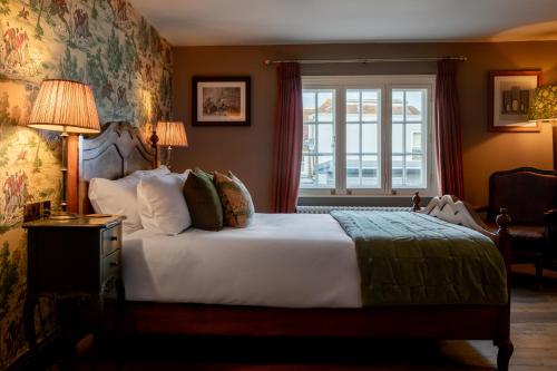 a bedroom with a large bed and a window at The Crown Inn in Bishops Waltham