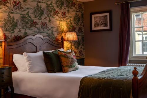 a bedroom with a bed with pillows on it at The Crown Inn in Bishops Waltham