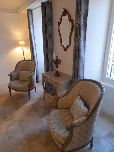 a living room with two chairs and a table at La Tour de Pezene in Anduze