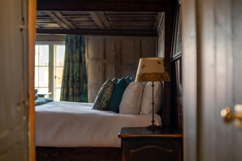 a bedroom with a bed and a lamp on a table at The Crown Inn in Bishops Waltham
