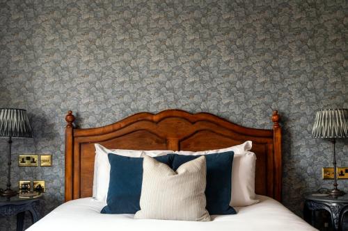 a bedroom with a bed with blue and white pillows at The Crown Inn in Bishops Waltham
