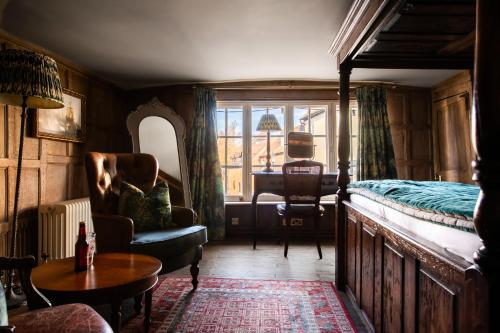 a bedroom with a bed and a couch and a table at The Crown Inn in Bishops Waltham