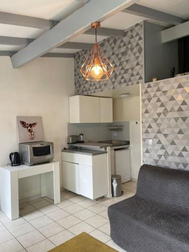 une cuisine avec une cuisinière et un micro-ondes dans l'établissement Jolie chartreuse avec jardin privé, à Toulouse