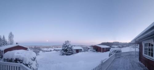 a snow covered yard with houses and buildings at Sunne Stugcenter 12 in Gräsmark