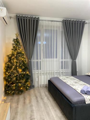 una camera da letto con un albero di Natale davanti a una finestra di Жилой комплекс Al-Farabi a Shymkent