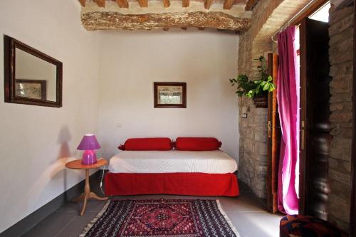 a bedroom with a bed and a table with a lamp at Gli Appartamenti Di Torre Bertona in Todi