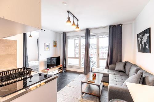 un salon avec un canapé et une télévision dans l'établissement GuestReady - Elevated Comfort with a Terrace!, à Paris