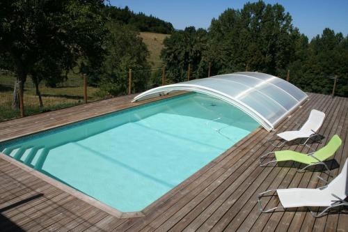 une piscine avec un parasol et des chaises sur le toit dans l'établissement Gîte La ferme de Taverne-Piscine privée chauffée, à Saint-Martin-la-Sauveté