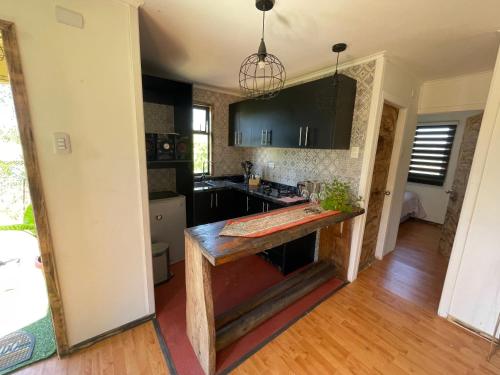 a kitchen with a wooden island in the middle at Cabaña Floppy Yumbel opción Tinaja in Yumbel