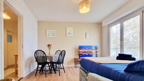 une chambre avec un lit, une table et des chaises dans l'établissement Le Petit Léon - Colmar - Fibre - RBNB, à Colmar