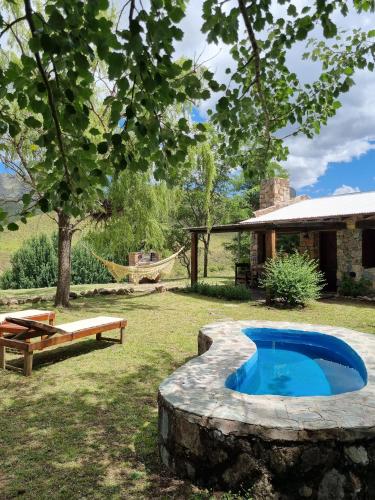 a pool in a yard with a hammock and a house at Estancia Altos del Durazno in Estancia Grande