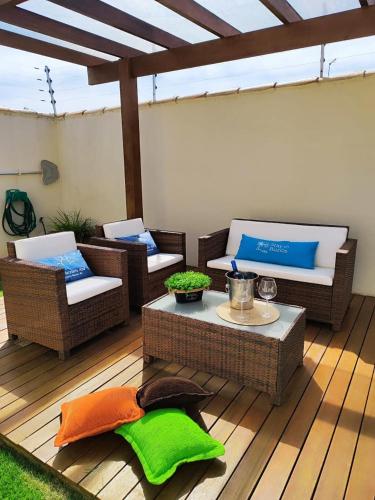 a patio with wicker chairs and a table on a deck at Horizonte Azul in Búzios