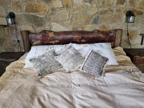 a bed with pillows and a log on it at Estancia Altos del Durazno in Estancia Grande