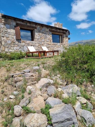 a stone building with a bench in front of it at Estancia Altos del Durazno in Estancia Grande