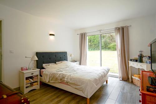 une chambre avec un lit et une grande fenêtre dans l'établissement Villa Bugatti - proximité 24h du Mans, à Changé