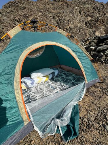 a green tent with a bed in the middle at The Out in Sinādil