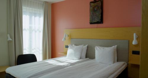 a bedroom with a bed with white sheets and pillows at Best Western Hotel Royal in Malmö