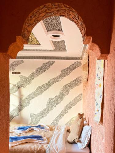 a room with a bed and a wall with a window at Panorama Guesthouse in Agadir