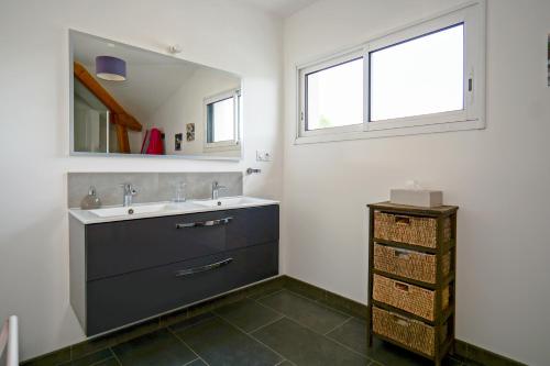 une salle de bain avec un lavabo et un miroir dans l'établissement Villa Bugatti - proximité 24h du Mans, à Changé