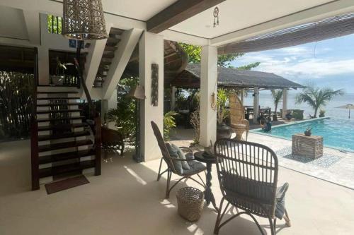 a house with a patio with a pool and chairs at Sirom Beach House in Tambobong