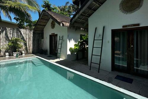 a house with a swimming pool in front of a house at Sirom Beach House in Tambobong