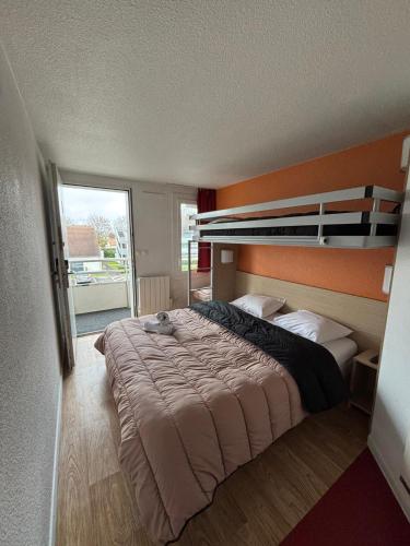 une chambre avec un grand lit avec un mur orange dans l'établissement Classic Hôtel - Fontenay-Trésigny, à Fontenay-Trésigny
