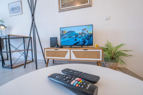 two remote controls sitting on a table in front of a television at ApArtStudio in Oliveira de Frades