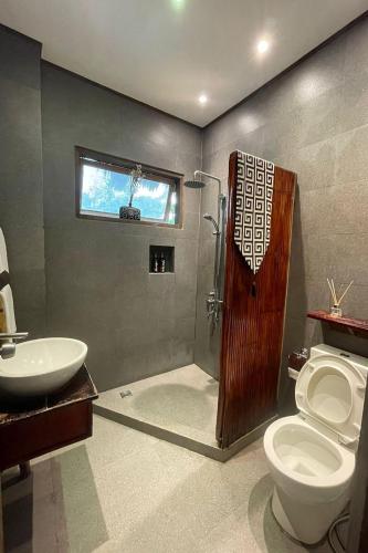 a bathroom with a shower and a toilet and a sink at Sirom Beach House in Tambobong