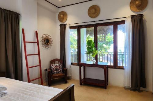 a bedroom with a bed and a window with a plant at Sirom Beach House in Tambobong