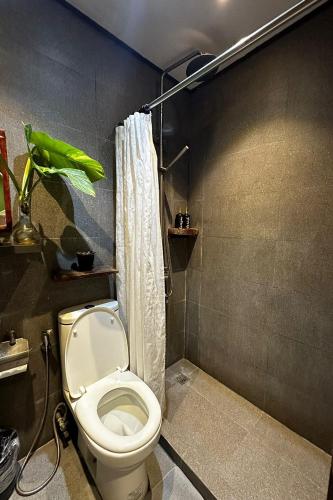 a bathroom with a white toilet and a shower at Sirom Beach House in Tambobong