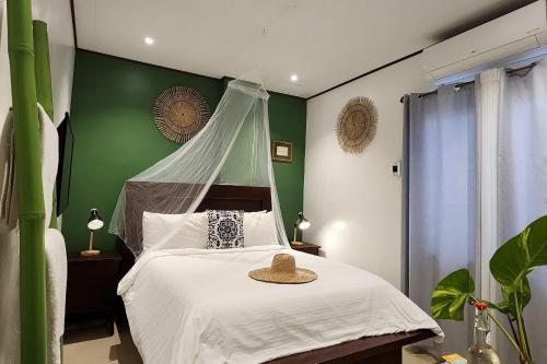 a bedroom with a bed with a hat on it at Sirom Beach House in Tambobong