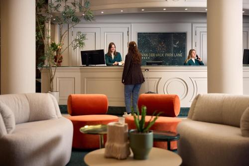 two women standing at a counter in a hotel lobby at Van der Valk Hotel Park Lane Antwerpen in Antwerp