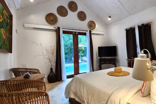 a room with a bed and a window and a television at Sirom Beach House in Tambobong