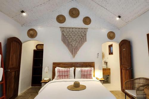 a bedroom with a bed with a hat on it at Sirom Beach House in Tambobong