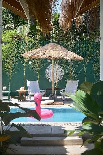 a pink rubber duck in a pool with an umbrella at Sirom Beach House in Tambobong