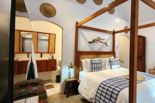 a bedroom with a canopy bed and a mirror at Sirom Beach House in Tambobong
