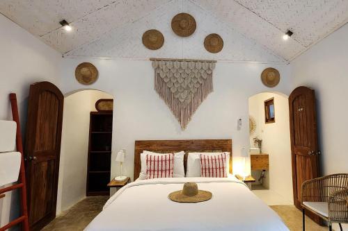 a bedroom with a large white bed with a hat on it at Sirom Beach House in Tambobong