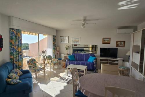 un salon avec un canapé bleu et une table dans l'établissement Bright apartment with terrace in Saint-Raphaël, à Saint-Raphaël