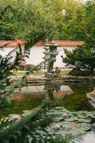 a person sitting next to a pond in a garden at Relaxace v blízkosti Poděbrad - Kanín in Poděbrady